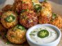 Cheesy jalapeño ranch chicken poppers served with a creamy dipping sauce on a platter.