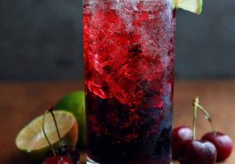 Midnight Malibu dirty soda served in a tall glass with ice, layered with cola, coconut cream, and lime, garnished with a lime wedge for a refreshing tropical twist.