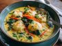 Simple coconut curry soup with dumplings served in a bowl, featuring golden broth, tender dumplings, fresh herbs, and a drizzle of coconut milk.