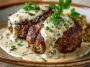 Juicy hamburger steaks smothered in creamy whiskey sauce, served with mashed potatoes and garnished with fresh herbs on a rustic plate.