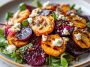 Creamy roasted beet salad with sweet potato cubes, crumbled feta cheese, and fresh greens drizzled with dressing, served on a rustic plate.