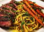 Cowboy butter steak linguine served in a rustic bowl with tender steak slices, creamy linguine tossed in cowboy butter sauce, roasted carrots, and fresh parsley garnish.
