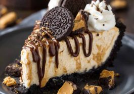 Unbelievable peanut butter pie with Oreo crust and creamy filling, topped with whipped cream and mini peanut butter cups, served chilled on a dessert plate.