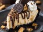 Unbelievable peanut butter pie with Oreo crust and creamy filling, topped with whipped cream and mini peanut butter cups, served chilled on a dessert plate.