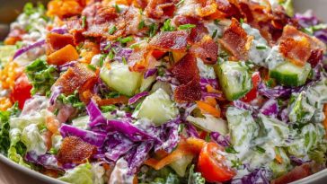 Bacon ranch chopped salad with lettuce, tomatoes, cheese, and crispy bacon pieces in a bowl.