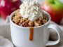 Protein apple crisp in a mug topped with golden oat crumble, warm cinnamon apples, and a dollop of Greek yogurt, served as a quick single-serve dessert.