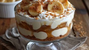 Cottage cheese banana pudding served in a glass dish with layers of creamy cottage cheese, sliced bananas, vanilla wafers, and whipped topping, garnished with fresh banana slices.