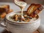 Cottage cheese mushroom soup served in a rustic bowl with creamy broth, tender mushrooms, cottage cheese, and fresh herbs, garnished with parsley.