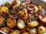 Crispy bacon honey roasted potatoes baked golden brown, drizzled with honey glaze, topped with crunchy bacon pieces, and garnished with fresh herbs on a serving platter.