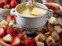 Assorted fondue recipes featuring melted cheese, chocolate, and broth fondues served with bread cubes, fruits, and vegetables on a festive table.