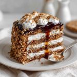 Oatmeal cream pie cake layered with moist oatmeal cake, fluffy cream filling, and topped with a drizzle of icing, served on a cake stand with rustic decor.