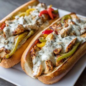 Ultimate chicken Philly cheese steaks served in toasted hoagie rolls, filled with juicy chicken, sautéed peppers, onions, and melted provolone cheese.