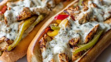 Ultimate chicken Philly cheese steaks served in toasted hoagie rolls, filled with juicy chicken, sautéed peppers, onions, and melted provolone cheese.