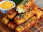 Golden brown potato cheese sticks served on a platter, crispy on the outside with melted cheese inside, paired with dipping sauces like marinara and ranch.