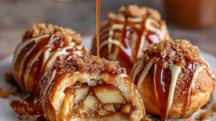 Simple caramel apple pie bombs baked golden brown, filled with gooey caramel, spiced apples, and flaky pastry, served warm with a drizzle of caramel sauce.