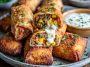 Chili’s Southwest eggrolls served golden brown and crispy, filled with chicken, black beans, corn, spinach, and cheese, with creamy avocado ranch dipping sauce on the side.