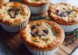 Mini mushroom and Gruyère pot pies baked golden brown with flaky pastry crust, creamy mushroom filling, and melted Gruyère cheese served in ramekins.