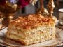 Russian Napoleon cake layered with flaky puff pastry and creamy custard filling, topped with powdered sugar and pastry crumbs.