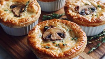 Mini mushroom and Gruyère pot pies baked golden brown with flaky pastry crust, creamy mushroom filling, and melted Gruyère cheese served in ramekins.