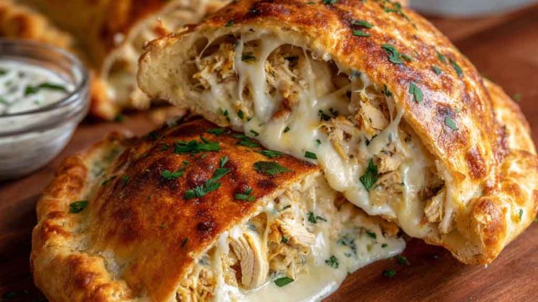 Crispy cheesy chicken Alfredo calzones baked golden brown, stuffed with creamy Alfredo sauce, tender chicken, and melted mozzarella, served with marinara dipping sauce.