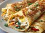 Thin golden crepes filled with scrambled eggs, cheese, and fresh herbs, folded and served as a savory breakfast dish.