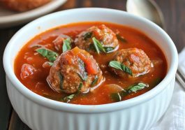 Hearty meatball tomato soup with tender beef meatballs, rich tomato broth, and fresh herbs served in a rustic bowl.