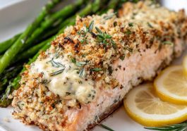 A golden-baked salmon fillet topped with creamy Boursin cheese and fresh herbs, served with roasted vegetables.
