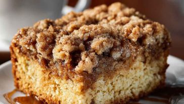 Moist crumb coffee cake topped with buttery cinnamon streusel and served with a cup of hot coffee.