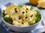 Creamy lemon caper egg salad served in a bowl with fresh herbs and crusty bread slices on the side
