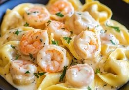 Creamy shrimp tortellini pasta tossed in a lemon garlic cream sauce, garnished with fresh parsley and served in a white bowl.
