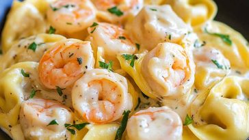Creamy shrimp tortellini pasta tossed in a lemon garlic cream sauce, garnished with fresh parsley and served in a white bowl.