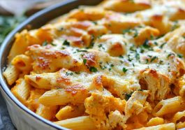 Pumpkin and chicken pasta bake topped with melted cheese in a casserole dish