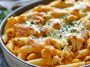 Pumpkin and chicken pasta bake topped with melted cheese in a casserole dish