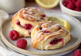 Freshly baked lemon raspberry cream cheese Danish rolls topped with glaze and filled with sweet raspberry and cream cheese filling.