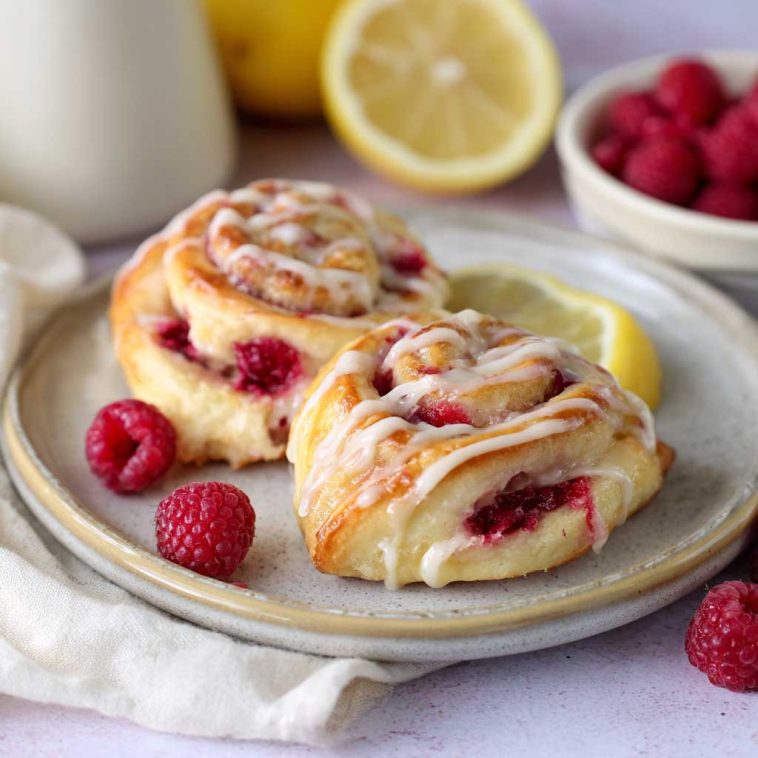 Freshly baked lemon raspberry cream cheese Danish rolls topped with glaze and filled with sweet raspberry and cream cheese filling.