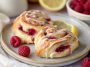 Freshly baked lemon raspberry cream cheese Danish rolls topped with glaze and filled with sweet raspberry and cream cheese filling.