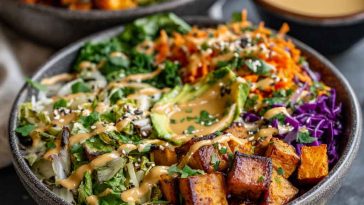 Colorful Thai peanut sweet potato Buddha bowl with roasted sweet potatoes, quinoa, fresh vegetables, and creamy peanut sauce.