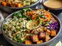 Colorful Thai peanut sweet potato Buddha bowl with roasted sweet potatoes, quinoa, fresh vegetables, and creamy peanut sauce.