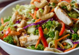 Fresh Chicken Cashew Crunch Salad with crisp lettuce, shredded carrots, crunchy cashews, tender chicken, and a creamy sesame dressing in a bright bowl.