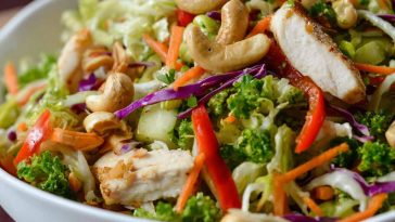 Fresh Chicken Cashew Crunch Salad with crisp lettuce, shredded carrots, crunchy cashews, tender chicken, and a creamy sesame dressing in a bright bowl.