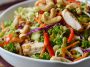 Fresh Chicken Cashew Crunch Salad with crisp lettuce, shredded carrots, crunchy cashews, tender chicken, and a creamy sesame dressing in a bright bowl.