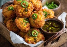 Crispy golden Jalapeno Corn Nuggets served with dipping sauce on a platter.