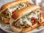 "Slow cooker chicken Philly sandwiches with melted provolone, sautéed peppers, and onions on hoagie rolls"