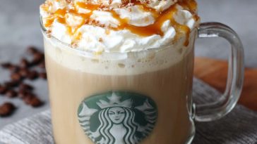 Homemade caramel brulée latte topped with whipped cream and caramel drizzle in a Starbucks-style mug