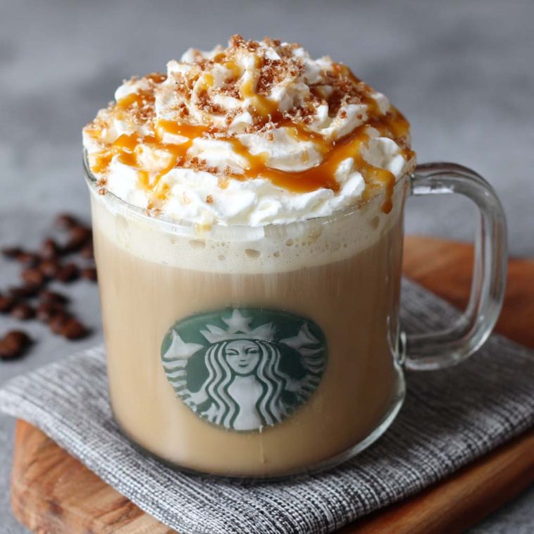 Homemade caramel brulée latte topped with whipped cream and caramel drizzle in a Starbucks-style mug