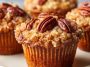 Freshly baked pecan pie brown sugar muffins topped with crunchy pecans and golden brown crust on a rustic tray.