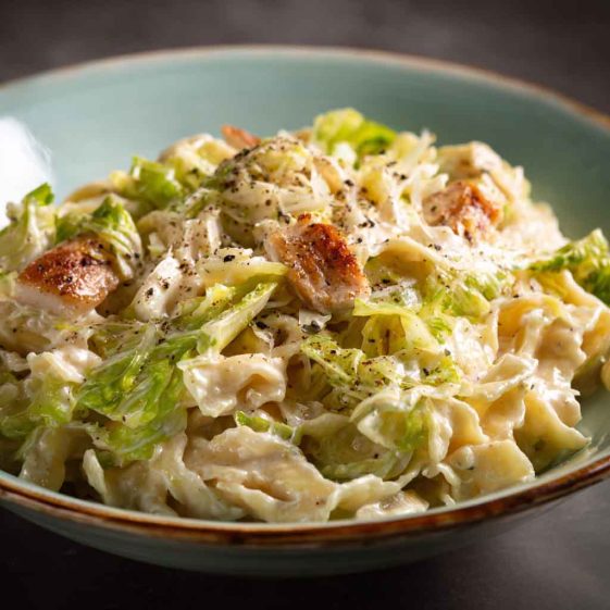 "Plate of creamy garlic Alfredo pasta with tender sautéed cabbage and parmesan garnish"