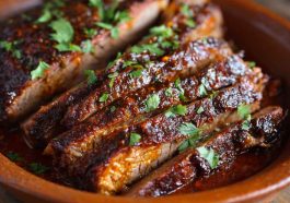Slow Cooked Beef Brisket with tender slices, caramelized onions, and rich gravy served on a wooden cutting board.