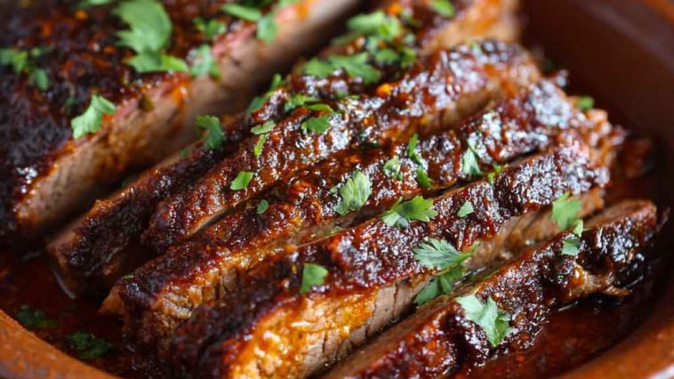 Slow Cooked Beef Brisket with tender slices, caramelized onions, and rich gravy served on a wooden cutting board.