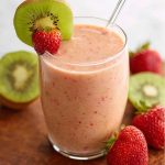 Refreshing strawberry‑kiwi smoothie served in a glass, garnished with fresh fruit slices and a sprig of mint.